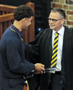 Headmaster congratulates a student at an awards ceremony