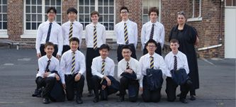Debating team standing in front of a building