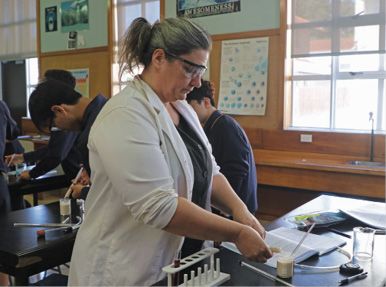 A teacher working at a table in a Biology lab